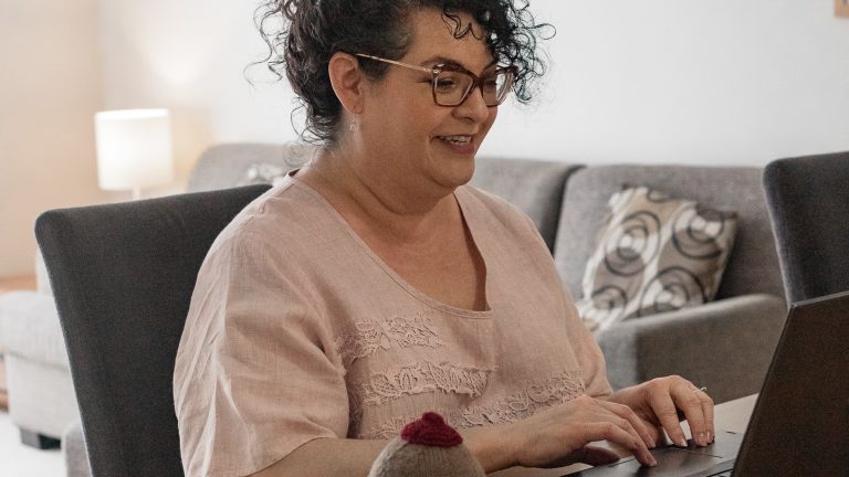 A picture of Natasha as she sits at a desk and types on her laptop